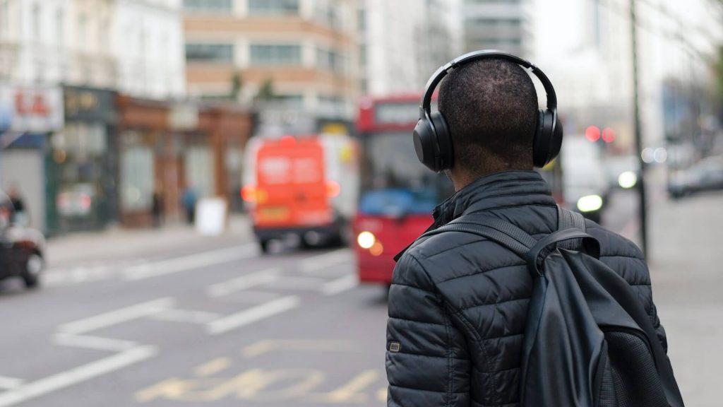 A guy walking around in the city while listening to music
